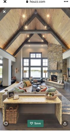 a large open living room with high vaulted ceilings and wood beams on the ceiling is filled with furniture