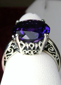 "Simulated Amethyst Ring K Ring Design#4 Custom Made This is a brand new Victorian design in solid sterling silver. The beautiful trellis filigree of the ring is amazing vintage style. This full cut sparkling gemstone is 13mm ( approximately 1/2\") in diameter. The inside of the band is marked 925 for sterling silver. It is a ring that will be treasured as an heirloom. Notice the beautifully intricate design of the silver filigree setting and trellis band. This alluring ring has beautiful shine Oval Purple Filigree Amethyst Ring, Oval Purple Amethyst Ring With Filigree, Oval Amethyst Ring With Intricate Design, Purple Oval Amethyst Ring With Filigree, Purple Amethyst Ring With Filigree, Intricate Amethyst Wedding Ring, Ornate Amethyst Purple Ring, Ornate Purple Amethyst Ring, Intricate Design Purple Amethyst Ring