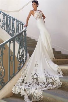 a woman in a white dress standing on some stairs