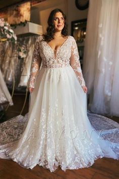 a woman in a wedding dress standing on a wooden floor