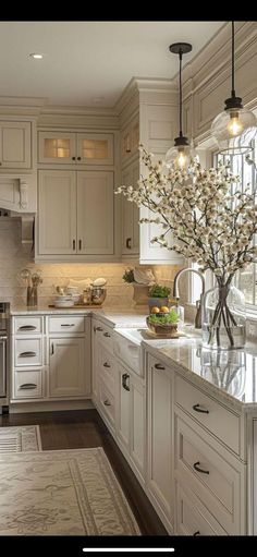 a large kitchen with white cabinets and marble counter tops, an area rug on the floor