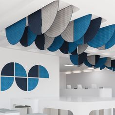 an office with blue and white circular shapes hanging from the ceiling, along with tables and chairs