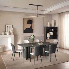 a modern dining room with white chairs and a black table in front of a fireplace