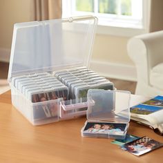 a plastic storage box filled with photos on a table