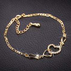 This is a really gorgeous heart bracelet with high quality cubic zirconia. It has a 18K real gold plating a link chain with extender chain and a lobster claw clasp. This gold bracelet with the two hearts looks much more beautiful in reality than in the photos. It makes a beautiful gift for young ladies and women of all ages.  Please check the size of your wrist before buying. You need one inch for closing the bracelet.  Size: 9-7/8 inches = 25cm  I can combine postage of multiple items providing they remain in the same price bracket (by dimensions and weight) as provided by the postage provider. For multiple item orders message me for shipping prices. The cost is almost always less than appears in your basket at checkout. More shipping options at check-out. A Jewellery box is available fro Heart Ankle Bracelet, Rhinestone Anklet, Color Bracelets, Heart Jewelry Set, Clear Heart, Copper Crystal, Leg Chain, Heart Anklet, Double Heart Necklace