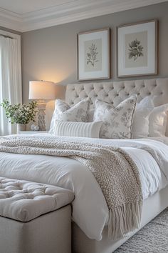 a white bed sitting in a bedroom next to two framed pictures on the wall above it