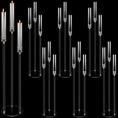 a bunch of candles that are in some kind of glass holder on a black background