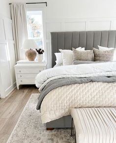 a bedroom with white walls and wood floors