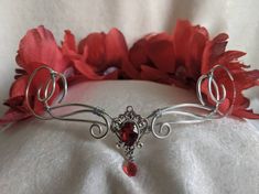 A beautiful, intricate crown with a ruby red crystal decorating the center of the silver wire and peonies in various shades of red surrounding the piece. Eyes will follow the delicate swirls and romantic peonies as the garland decorates your head, perfect for renaissance fairs, weddings, cosplay, or any event of your choosing! Object References, Woodland Tiara, Flower Tiara, Kit Ideas, Wire Flowers, Red Peonies, Crystal Crown, Custom Earrings, Bride Style