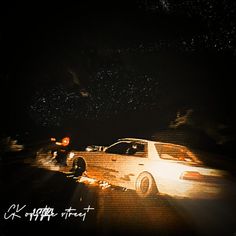 a white car parked on the side of a road at night with stars in the sky