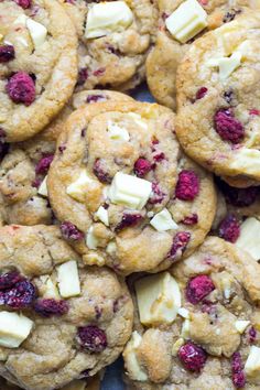 cranberry white chocolate chip cookies are piled on top of each other with butter