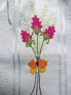 a close up of a towel with flowers embroidered on the front and back of it