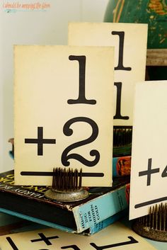 two wooden signs with numbers on them sitting next to each other in front of books