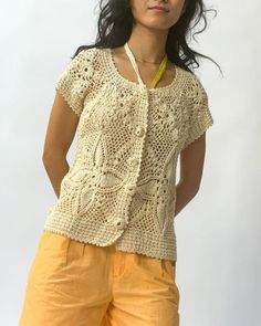 a woman wearing yellow shorts and a crocheted top with an openwork design