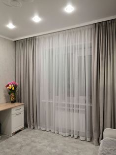 a living room with curtains and a desk