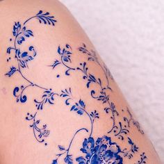 a woman's thigh with blue flowers on it