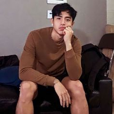 a young man sitting on top of a black couch