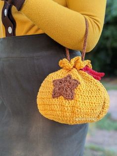 a woman is holding a crocheted purse