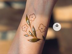 a woman's wrist with flowers painted on it