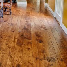 an empty hallway with wooden floors and yellow walls