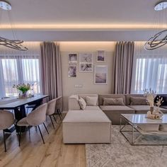 a living room filled with lots of furniture next to a dining room table and chairs