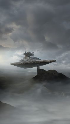 a large ship floating on top of a body of water surrounded by fog and clouds