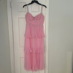 a pink dress hanging on a white door