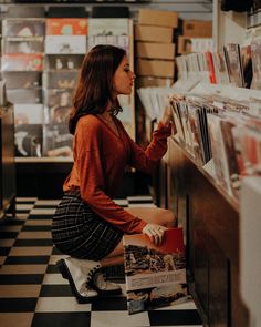 a woman sitting on the floor looking at records