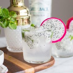 two glasses filled with watermelon and mint spritkles on a cutting board