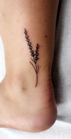 a small tattoo on the foot of a woman's ankle with flowers in it