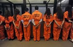 a group of people in orange prison uniforms