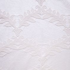 an embroidered fabric with white flowers and leaves on the bottom, as if it were made out of linen