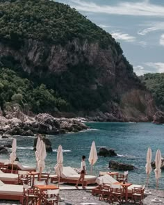 chairs and umbrellas are set up on the beach by the water's edge