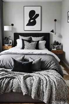 a large bed sitting in a bedroom next to a window with black and white decor