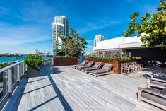 an outdoor deck with lounge chairs overlooking the ocean