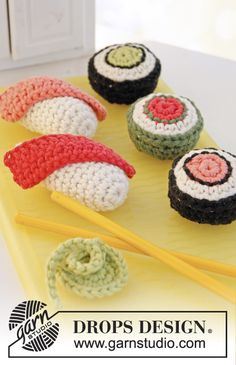 crocheted sushi and chopsticks on a yellow tray