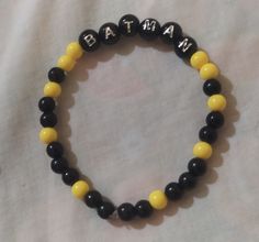 a black and yellow beaded bracelet with the word baby on it's side