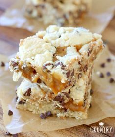 two pieces of dessert sitting on top of parchment paper next to each other with chocolate chips