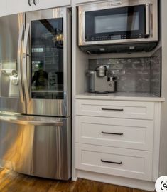 a metallic refrigerator freezer sitting inside of a kitchen