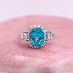 This stunning 6-carat oval-cut blue zircon has a light blue color with the perfect amount of dark flashes. An absolutely stunning ring for an engagement or any kind of statement! This NNJ Designs' original ring setting features a mix of round and baguette natural earth-mined diamonds creating an elegant and beautiful ring! This ring can be a lovely December birthstone gift for your loved ones! As listed, this ring is ready to ship. If you're interested in purchasing this setting with a different Blue Zircon Ring, Designer Silver Jewellery, Jewelry Showcases, Baguette Diamonds, Birthstone Gifts, Zircon Ring, Ring Setting, Blue Zircon, December Birthstone