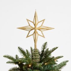 a gold star ornament on top of a christmas tree