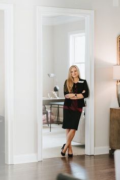 a woman standing in a living room next to a door