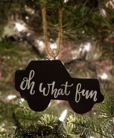 a black ornament hanging from a christmas tree with the words oh what fun on it