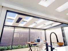 an open kitchen with glass walls and sliding doors