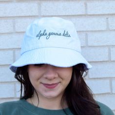 Be your own icon today, in this classic accessory! Perfect for bid day, big-little, or a little treat for yourself. This hat will have your sorority name embroidered in an elegant font in the thread color of your choice. 8.25 oz (275-285 gsm)., 100% bio-washed chino twill Unstructured, 31/2" crown Sewn eyelets 2" brim (tolerance 1/2") One Size Fits Most: 7 1/2 - 7 5/8 ﻿Thread Colors: Adjustable Hats With Letter Print For Graduation, Adjustable White Hats For Graduation, Adjustable White Hat For Graduation, Personalized Adjustable Bucket Hat, White Adjustable Hat With Letter Embroidery, Adjustable White Hat With Letter Embroidery, Sorority Names, White Bucket Hat, Alpha Gamma Delta