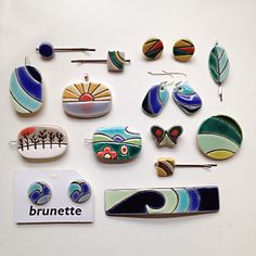 a collection of brooches and ear pins on a white surface with the words brunette written below them