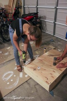 two women are working on wood in a garage