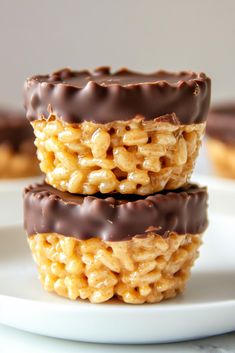 three chocolate covered cookies sitting on top of a white plate