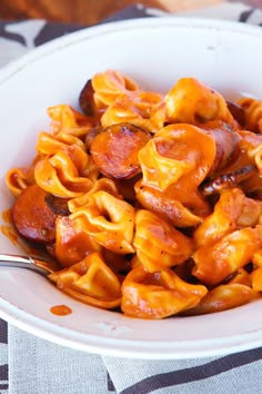 a white bowl filled with pasta and sausage