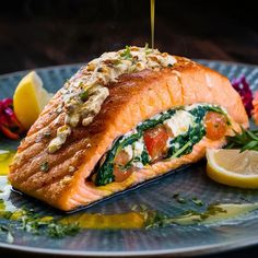 a piece of salmon is being drizzled with olive oil on a plate